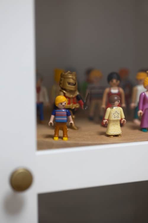 Juguetes Playmobil en un estante de un armario blanco.